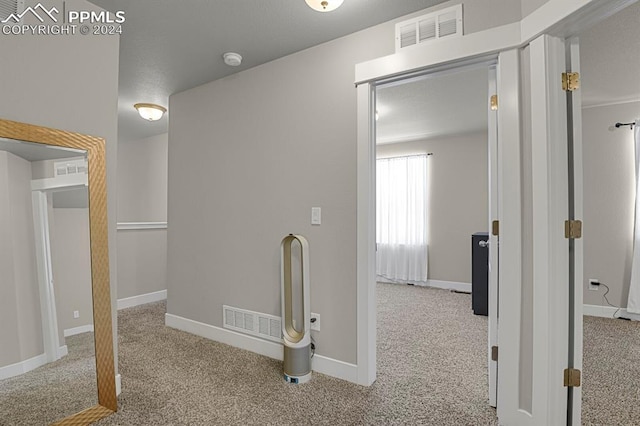 hallway featuring light colored carpet