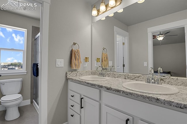 bathroom with ceiling fan, vanity, a shower with shower door, tile patterned floors, and toilet