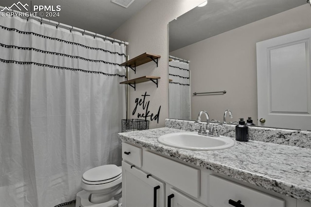 bathroom with vanity, toilet, and curtained shower