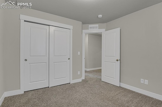 unfurnished bedroom with carpet floors and a closet