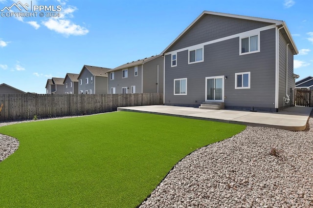 rear view of property featuring a lawn and a patio area