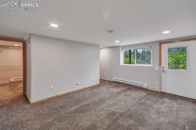 carpeted spare room featuring a baseboard radiator