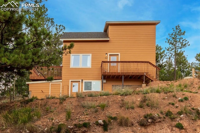 rear view of property featuring a wooden deck