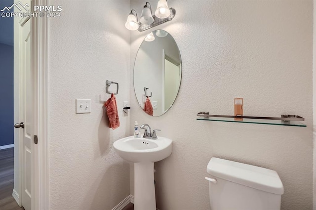 bathroom with an inviting chandelier, toilet, and hardwood / wood-style floors