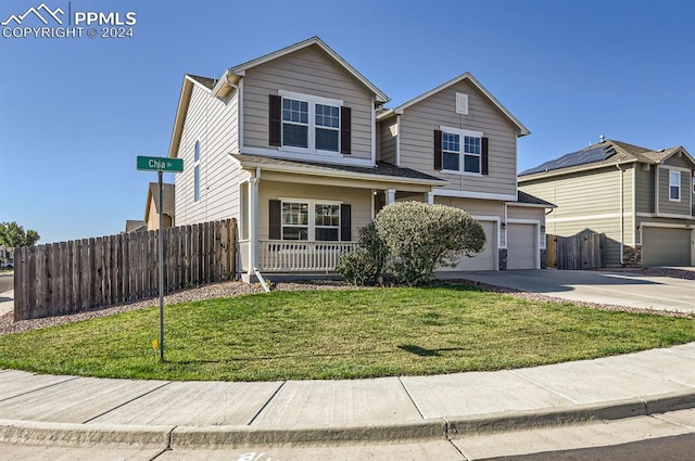 front of property featuring a garage, covered porch, and a front lawn