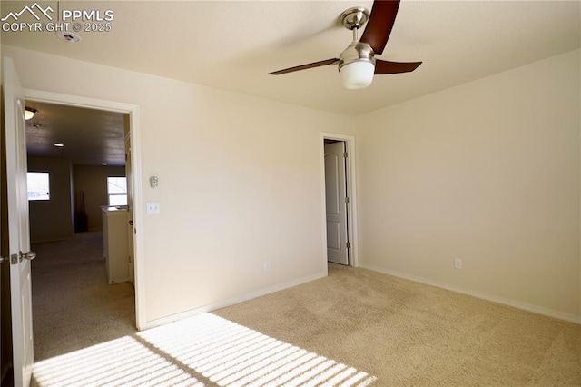 spare room featuring light colored carpet and ceiling fan