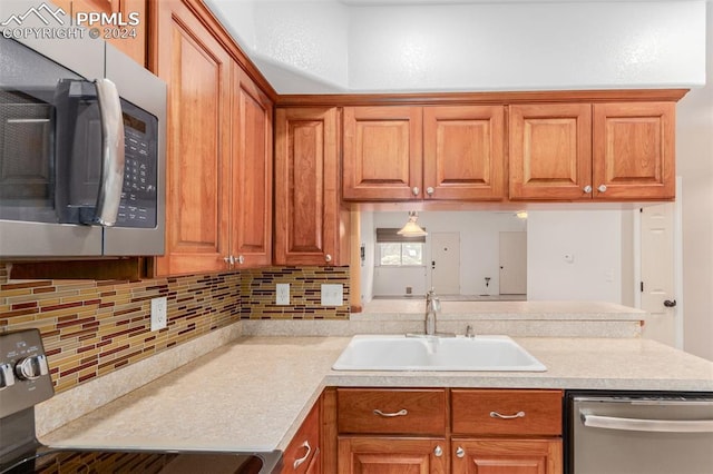 kitchen featuring sink, appliances with stainless steel finishes, and decorative backsplash