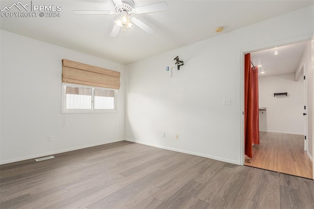 unfurnished room with ceiling fan and light hardwood / wood-style floors