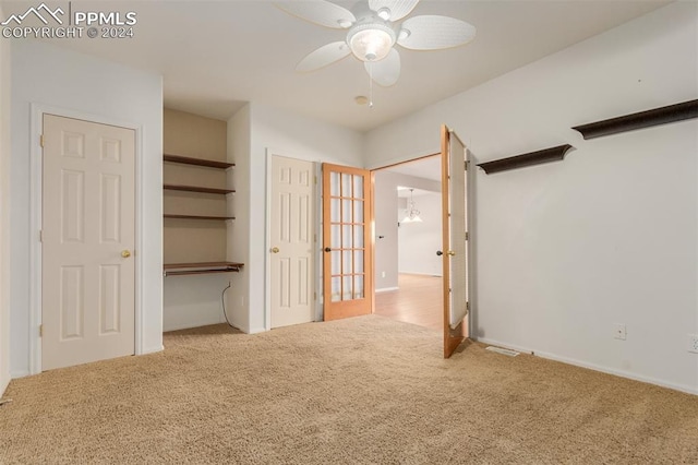 unfurnished bedroom featuring a closet, ceiling fan, light carpet, and french doors