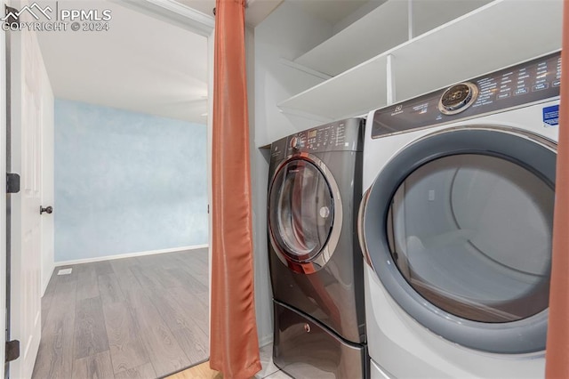 washroom with washer and dryer and light hardwood / wood-style floors