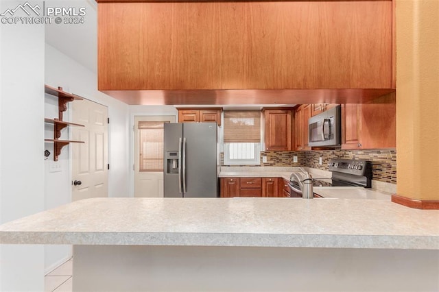 kitchen featuring appliances with stainless steel finishes, decorative backsplash, and kitchen peninsula