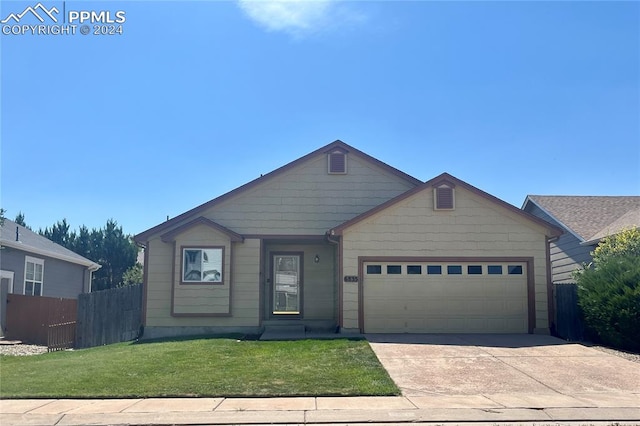 view of front of house with a garage and a front lawn