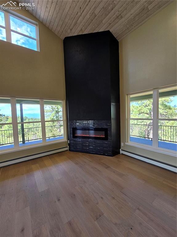 unfurnished living room with wooden ceiling, a wealth of natural light, and wood-type flooring