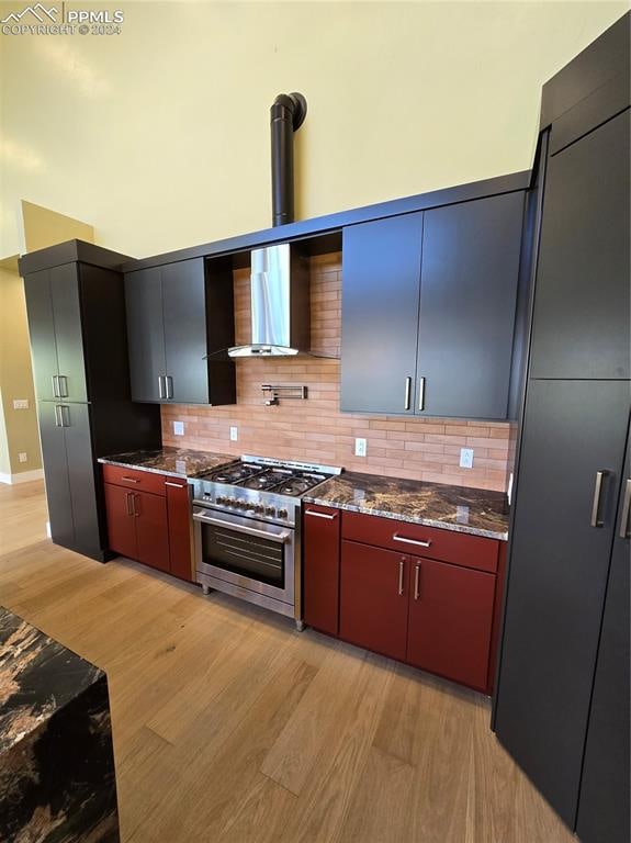 kitchen with light wood-type flooring, double oven range, and decorative backsplash