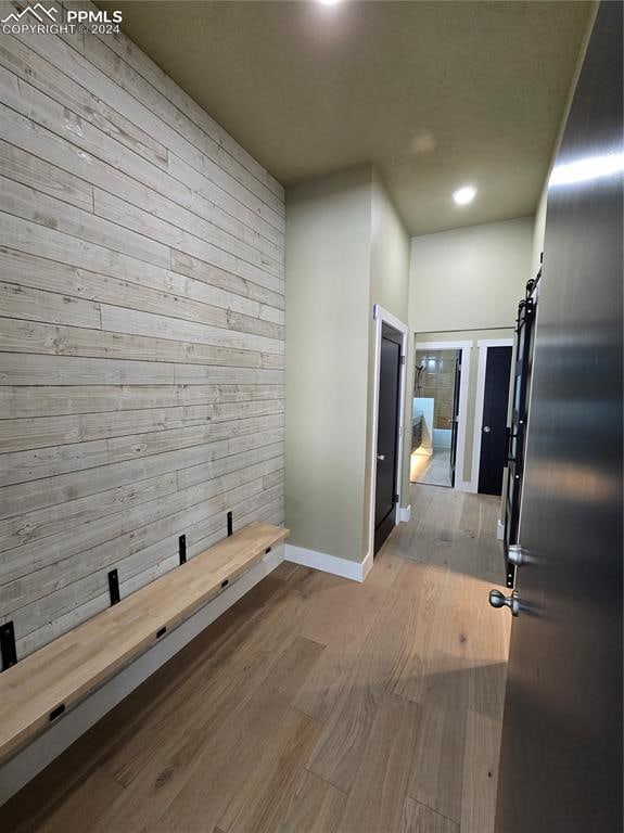 hallway with light wood-type flooring and a barn door