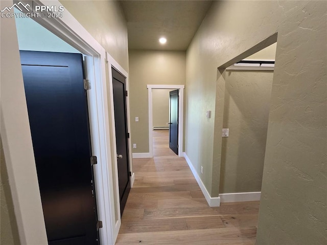 hall featuring light hardwood / wood-style flooring and baseboard heating