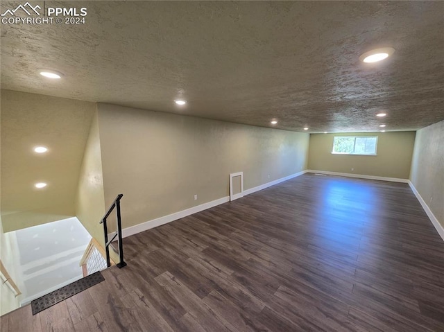 basement with a textured ceiling and dark wood-type flooring