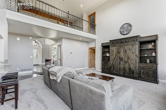 living room with light carpet and a high ceiling