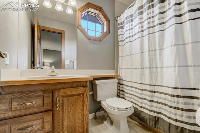 bathroom with tile patterned flooring, vanity, and toilet