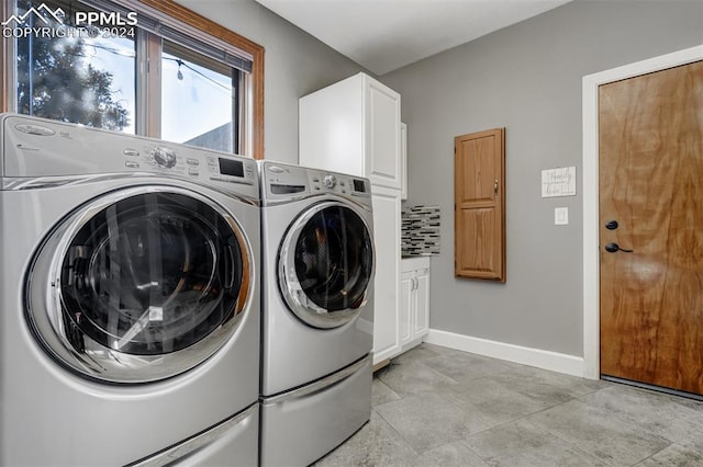 clothes washing area with cabinets and washer and dryer