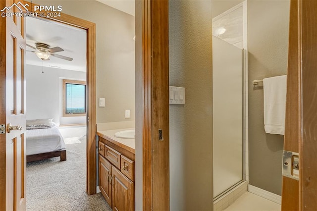 bathroom featuring vanity, a shower with shower door, and ceiling fan