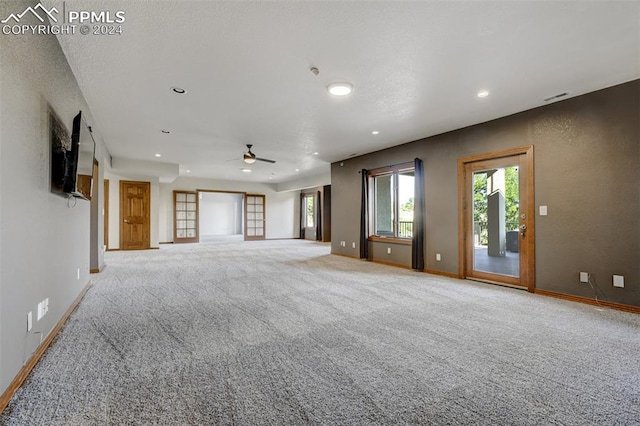 unfurnished living room featuring light colored carpet and ceiling fan