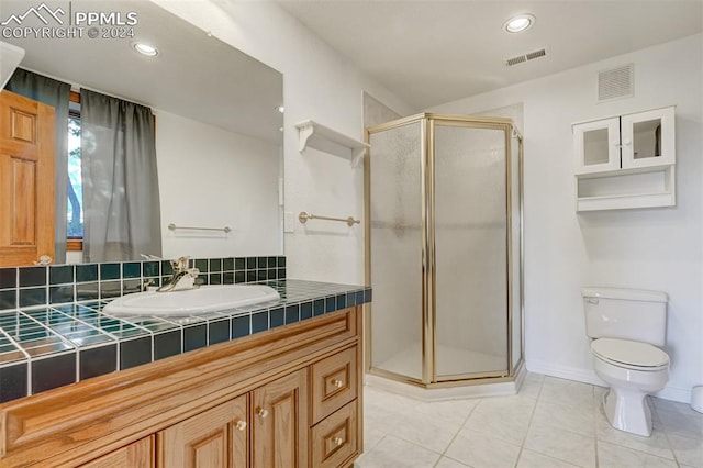 bathroom with tile patterned flooring, walk in shower, vanity, and toilet