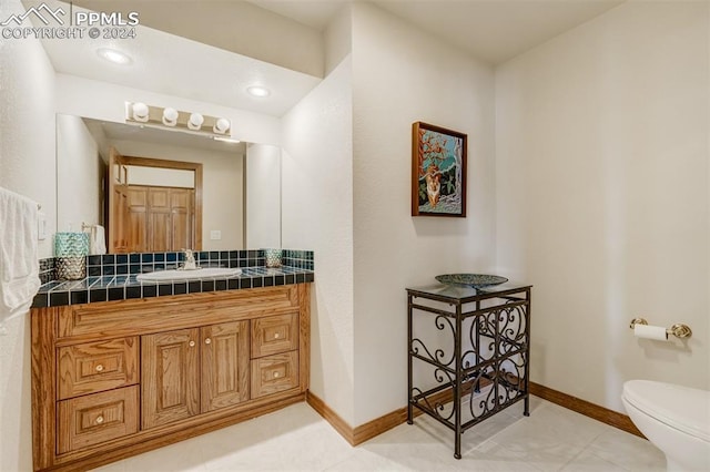 bathroom with vanity, toilet, and tile patterned flooring