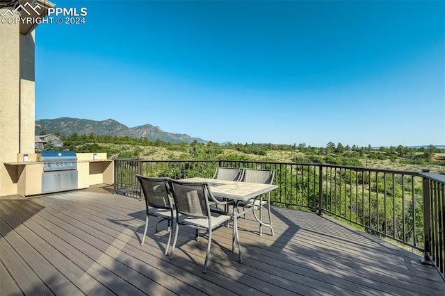 deck with exterior kitchen, grilling area, and a mountain view