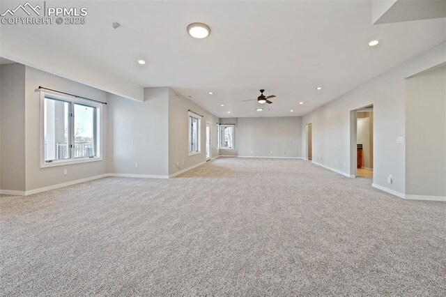 unfurnished living room featuring light carpet, a healthy amount of sunlight, and ceiling fan