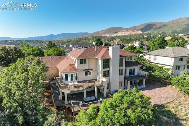 rear view of property featuring a balcony and a mountain view