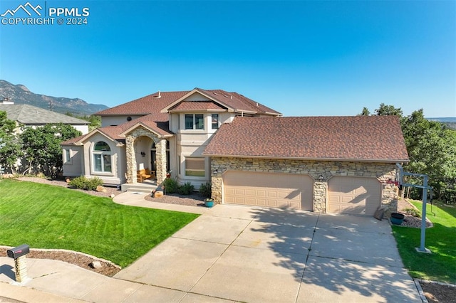 view of front of house with a garage, a mountain view, and a front yard