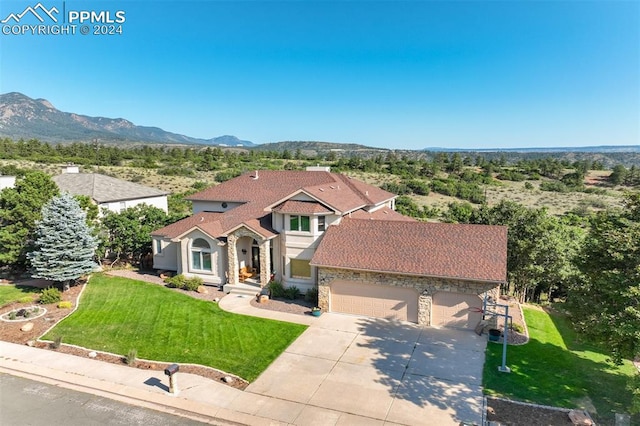 mediterranean / spanish-style house with a mountain view, a garage, and a front lawn