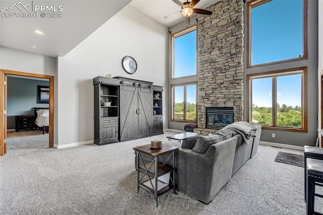 living room with high vaulted ceiling, plenty of natural light, ceiling fan, a fireplace, and carpet