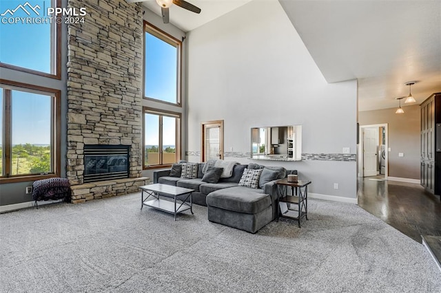 living room featuring a towering ceiling, a fireplace, and ceiling fan