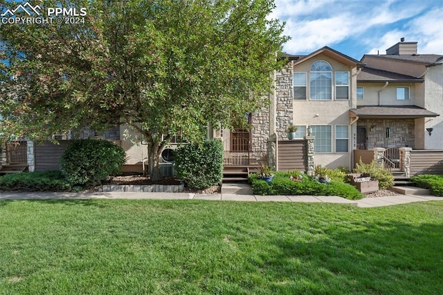 view of property featuring a front yard and a wooden deck