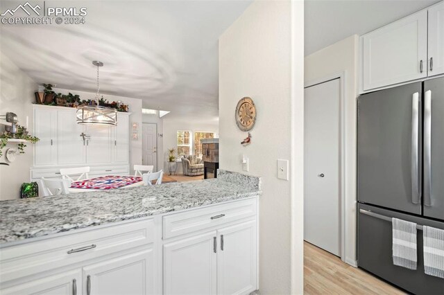 kitchen with appliances with stainless steel finishes, white cabinetry, hardwood / wood-style floors, and sink