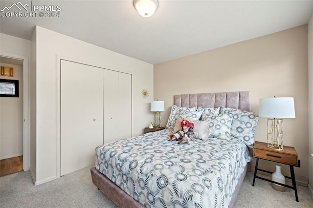 bedroom featuring light carpet and a closet