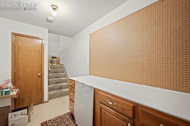 bathroom with vanity, tiled bath, tile patterned floors, and vaulted ceiling