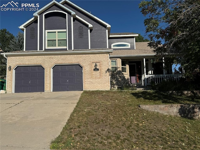 view of front of home featuring covered porch, a garage, and a front yard