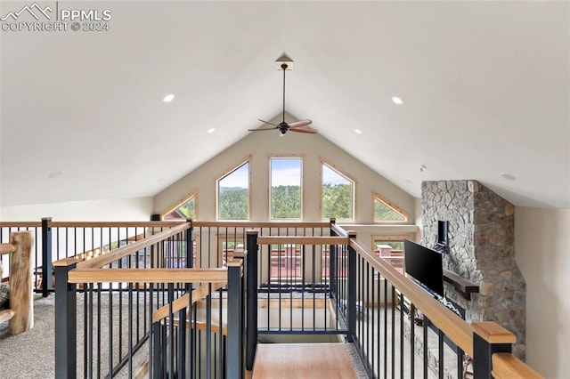 corridor with hardwood / wood-style floors and vaulted ceiling