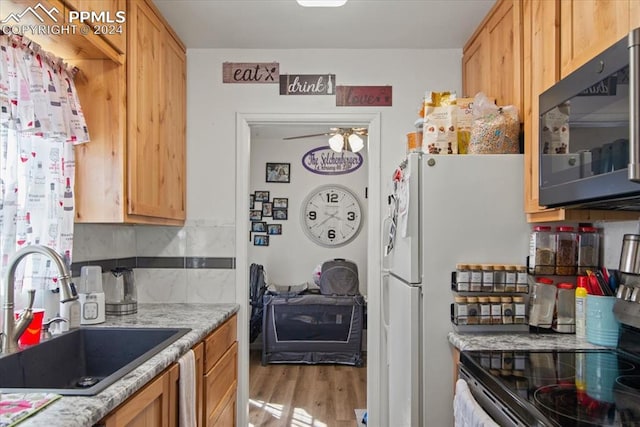 kitchen with backsplash, stainless steel appliances, light hardwood / wood-style floors, sink, and ceiling fan