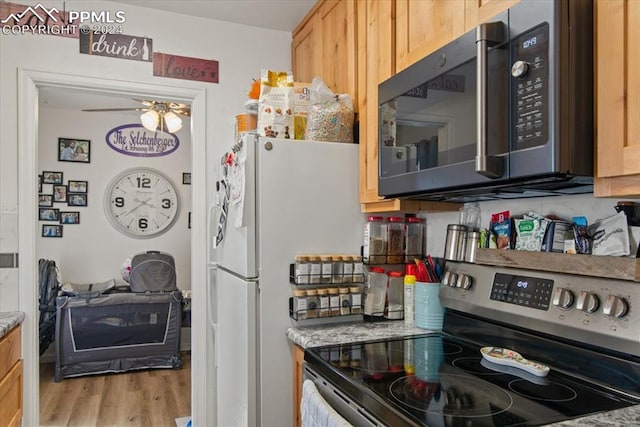 kitchen featuring light stone countertops, light brown cabinetry, light hardwood / wood-style floors, stainless steel appliances, and ceiling fan