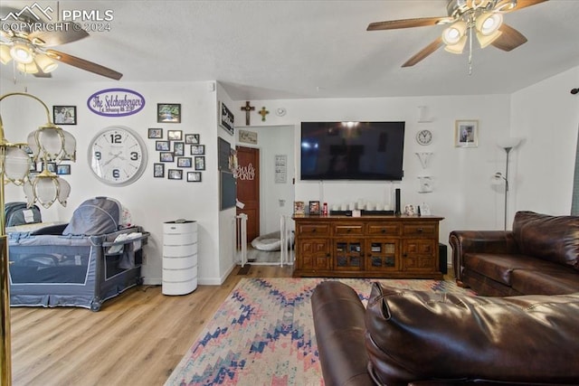 living room with ceiling fan and light hardwood / wood-style flooring