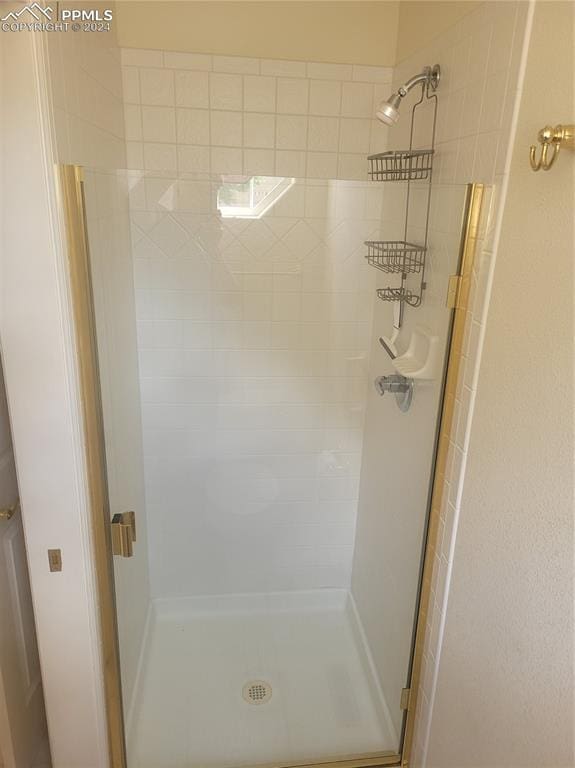 bathroom featuring a shower with door