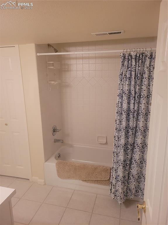 bathroom featuring vanity, shower / bathtub combination with curtain, and tile patterned flooring