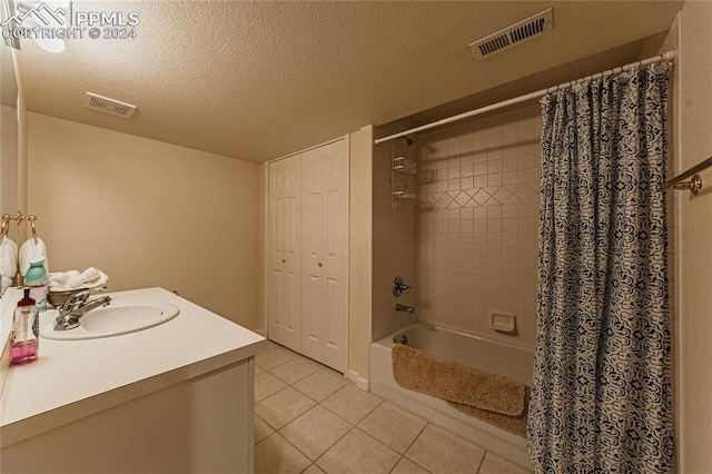 bathroom featuring vanity, a textured ceiling, shower / bath combo, and tile patterned flooring