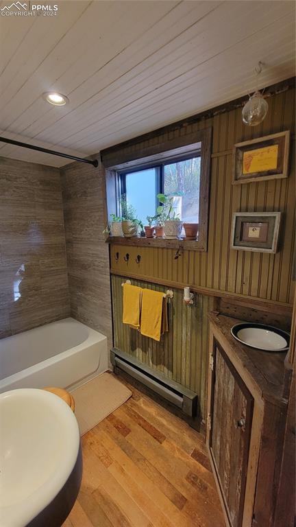 231 Plainview Pl, Manitou Springs, CO 80829 - bathroom featuring wooden walls, a baseboard heating unit, wood ceiling, wood finished floors, and  shower combination