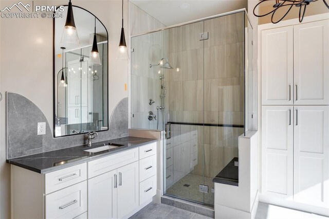 bathroom featuring vanity, backsplash, a shower with shower door, and tile patterned flooring