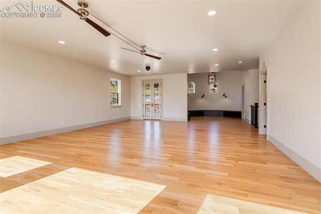 unfurnished living room with french doors, light hardwood / wood-style floors, and ceiling fan